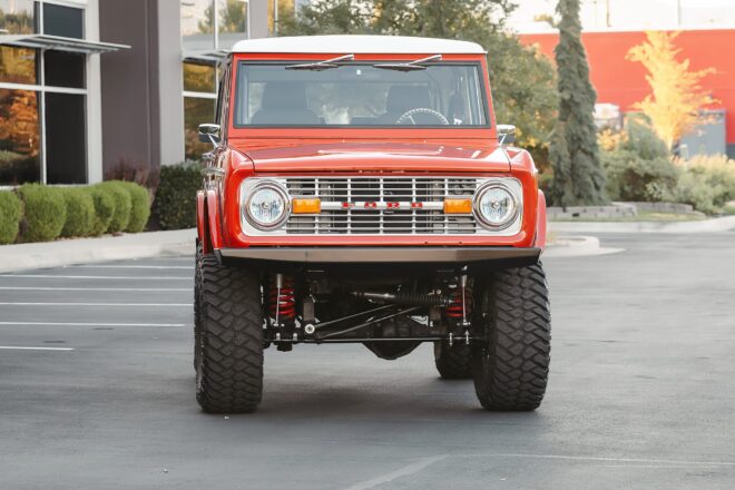 Roter 1968 Ford Bronco frontal mit weißem Hardtop und Höherlegung