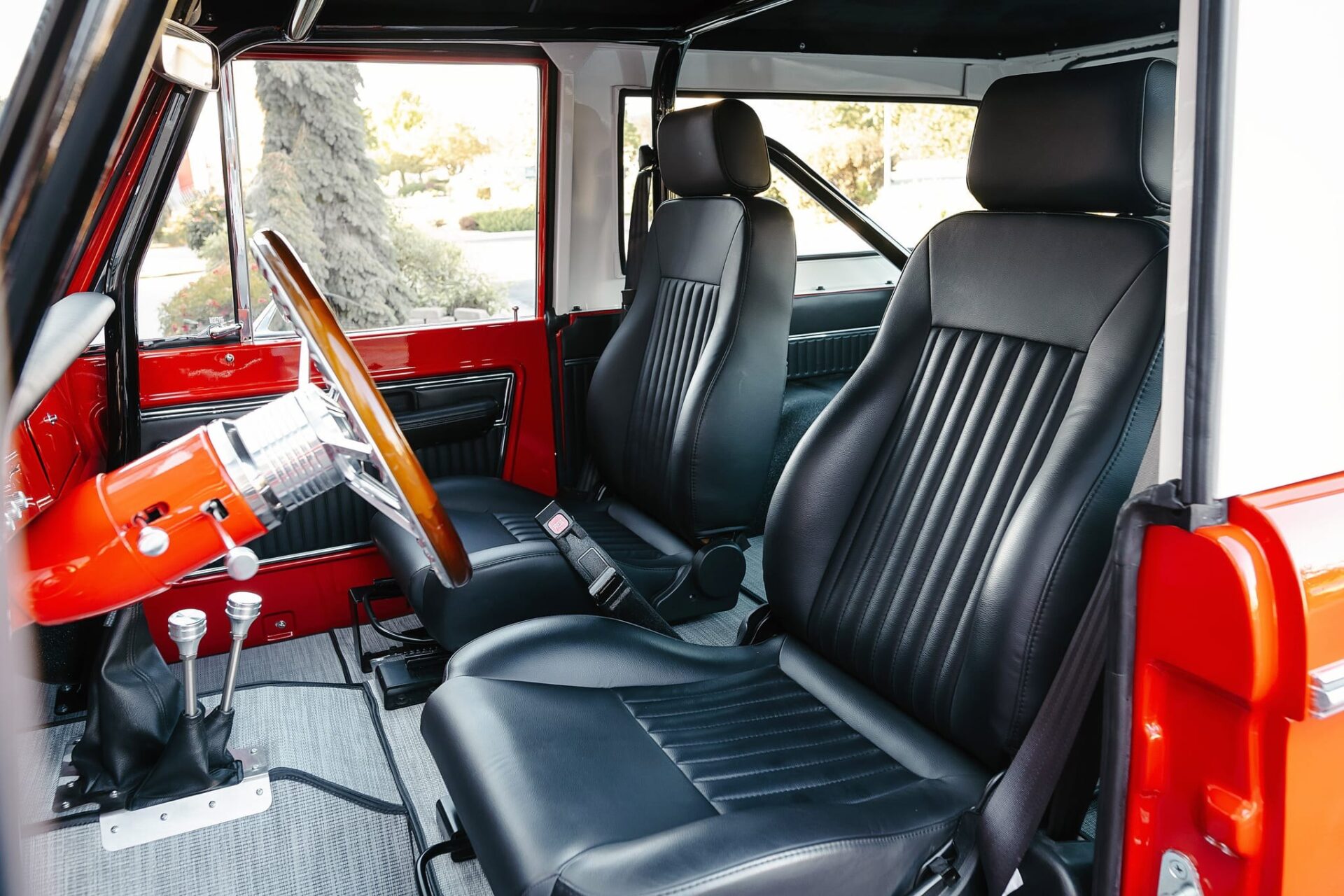 Schwarzer Innenraum des 1968 Ford Bronco mit Holzlenkrad und Twin-Stick-Schaltern
