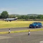 Range Rover Sport Electric auf einer Teststrecke neben einem Flugzeug