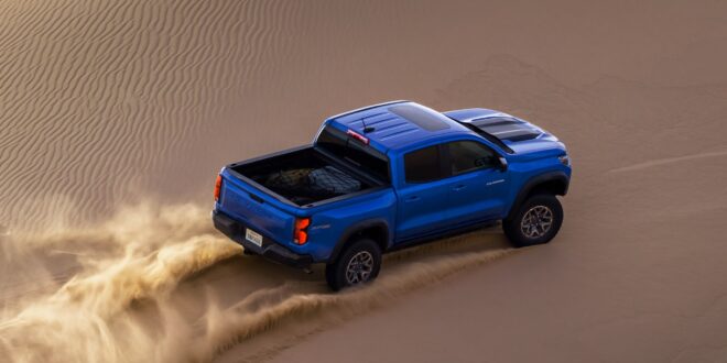 Blauer Chevrolet Colorado ZR2 fährt mit Staubfahne durch eine Sanddüne