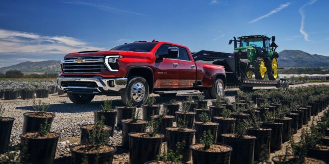 Roter Chevrolet Silverado 2500HD mit Tieflader und Traktor