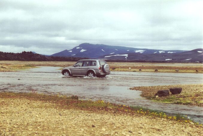 Geländewagen fährt langsam durch eine flache Furt bei Landmannalaugar in Island