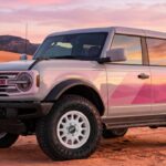Ford Bronco Desert Rising mit weißer Karosserie und Magenta-Grafik in der Wüste