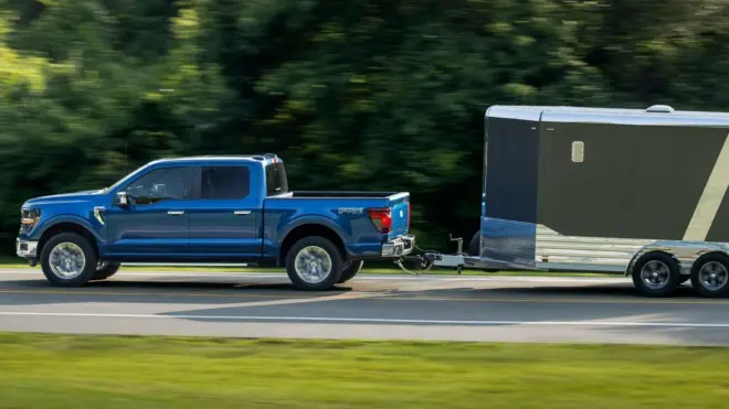 Blauer Ford F-150 zieht einen zweiachsigen geschlossenen Kastenanhänger
