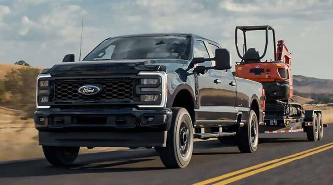 Ford F-250 Super Duty mit Tieflader und Bagger auf einer Straße