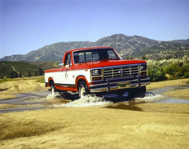 Rot-weißer 1984 Ford F-150 bei einer Wasserdurchfahrt