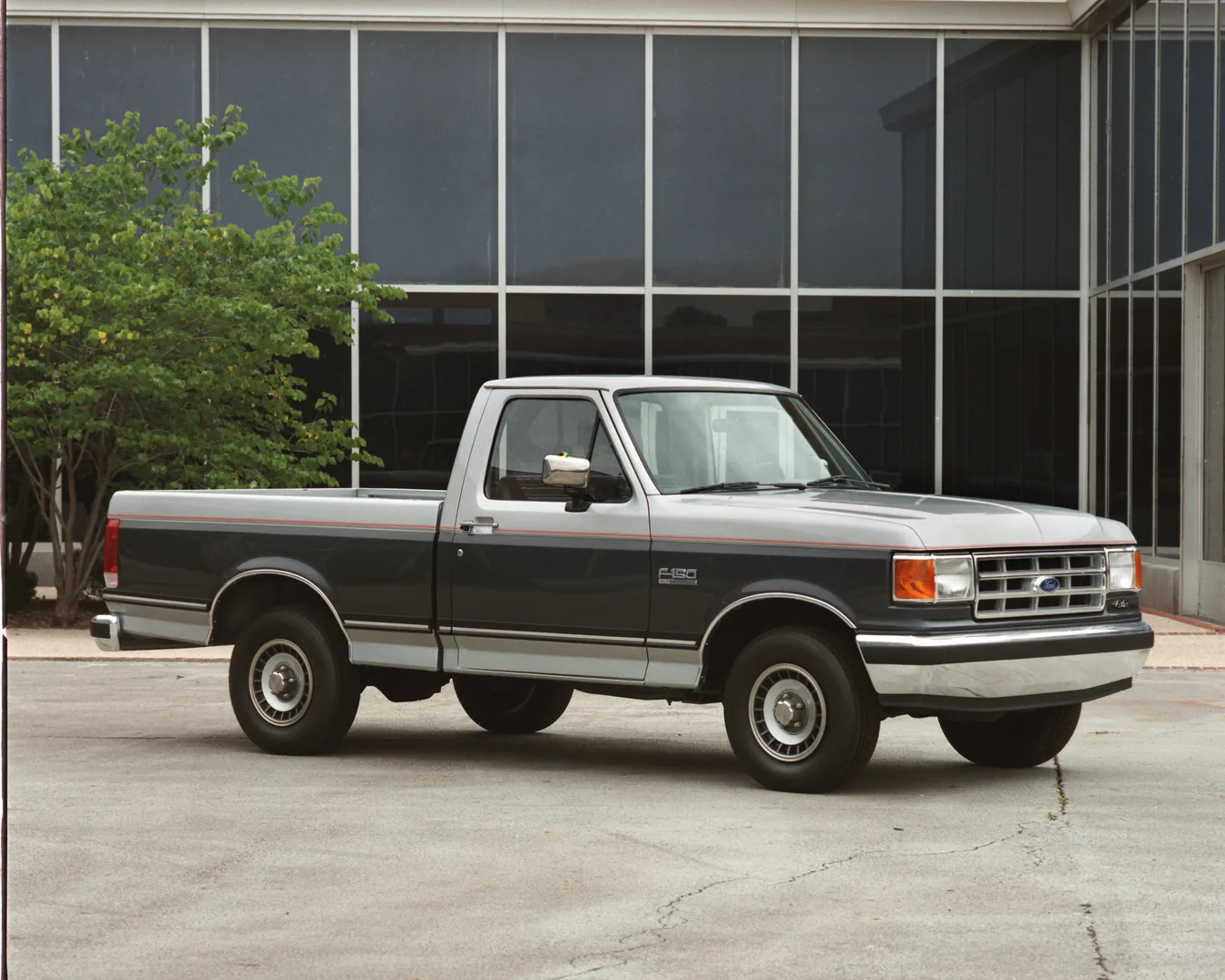 Dunkler 1986 Ford F-150 XLT vor einem Bürogebäude