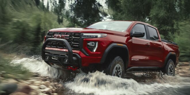Roter GMC Canyon AT4X durchquert einen steinigen Bach