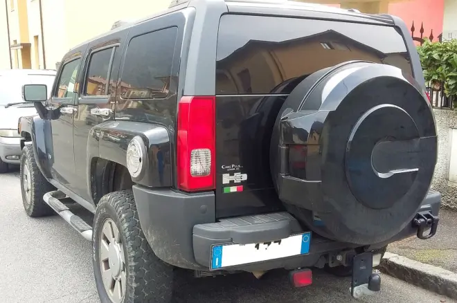 Schwarzer Hummer H3 in Heck-Dreiviertelansicht mit außen montiertem Ersatzrad