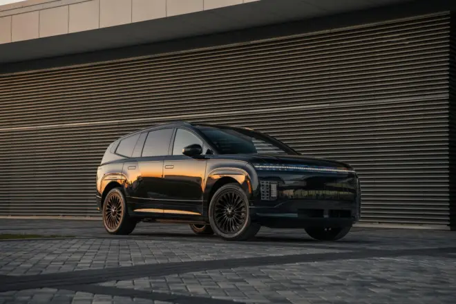 Schwarzer Hyundai Ioniq 9 Calligraphy Black Ink in Front-Dreiviertelansicht vor moderner Architektur