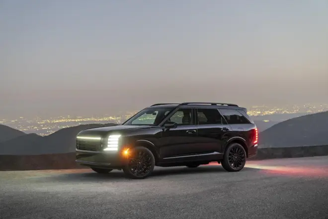 Schwarzer Hyundai Palisade Night Package in Front-Dreiviertelansicht bei Nacht über einer Stadt