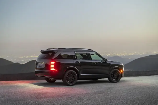 Schwarzer Hyundai Palisade Night Package in Seitenansicht bei Nacht über einer Stadt