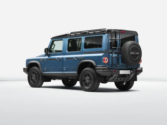 Blauer Ineos Grenadier Station Wagon in Heck-Dreiviertelansicht mit Reserverad an der Hecktür