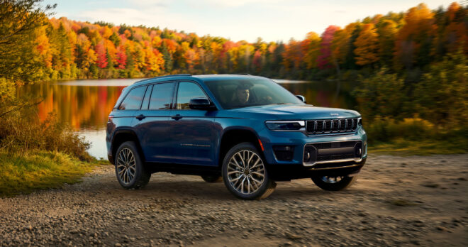 Blauer Jeep Grand Cherokee Overland 2027 in Front-Dreiviertelansicht auf einem Schotterweg
