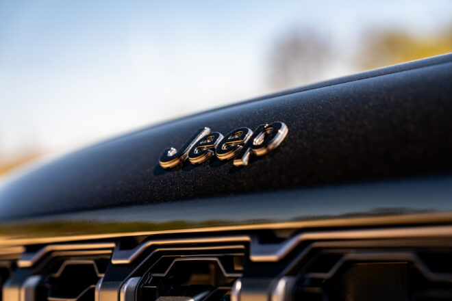 Nahaufnahme des Jeep-Schriftzugs an der Front des schwarzen Grand Cherokee Trailhawk 2027