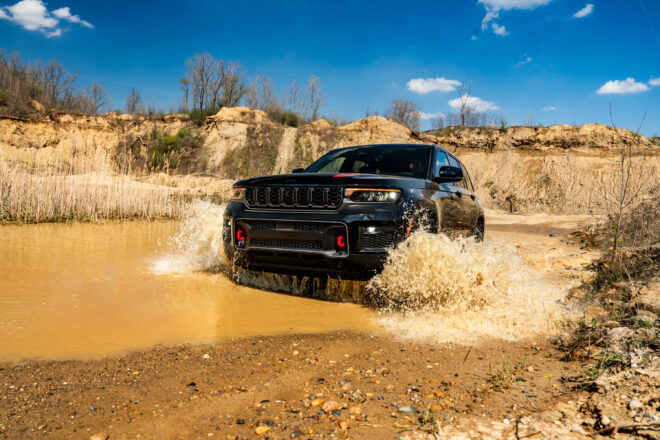 Schwarzer Jeep Grand Cherokee Trailhawk 2027 bei einer Wasserdurchfahrt im Gelände