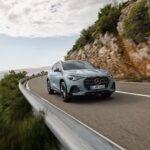 Hellblauer Mercedes GLA 2028 Hybrid auf einer Küstenstraße