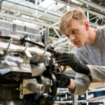 AvtoVAZ-Mitarbeiter bei der Montage eines Motors für den Lada Niva Legend
