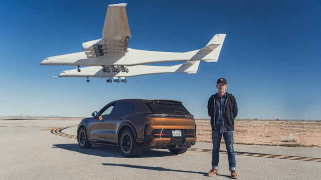 Rennfahrer Patrick Long neben dem Porsche Cayenne Turbo Electric während der Stratolaunch Roc landet