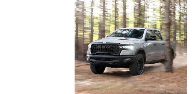 Grauer Ram 1500 fährt auf einem Weg durch einen Wald