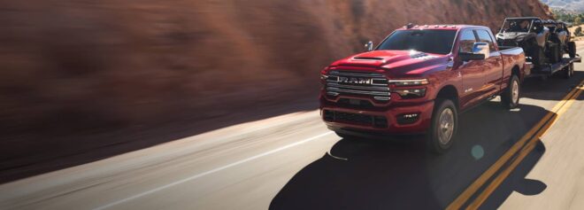Roter Ram 2500 Laramie mit Anhänger und zwei Geländefahrzeugen