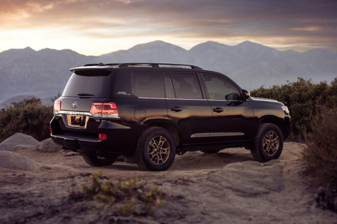Offizielles Toyota-Pressebild eines schwarzen Land Cruiser Heritage Edition vor einer Bergkulisse