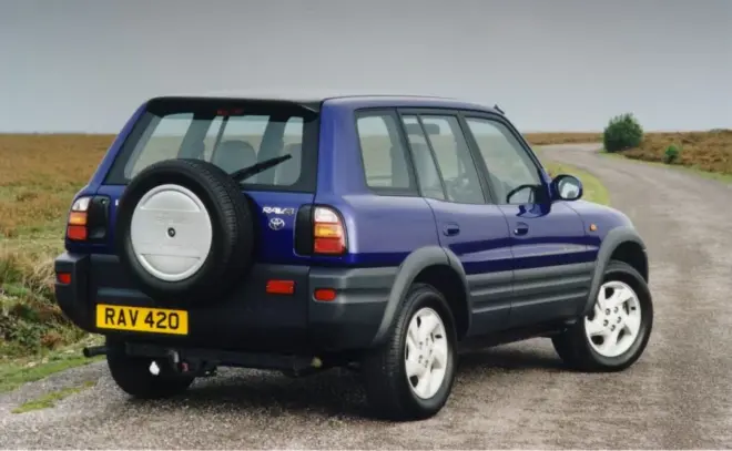 Blauer fünftüriger Toyota RAV4 der ersten Generation in Heck-Dreiviertelansicht mit außen montiertem Ersatzrad
