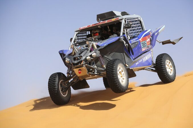 Blauer Yamaha-Rallybuggy mit der Startnummer 385 springt bei der Rally Dakar 2021 über eine Sanddüne